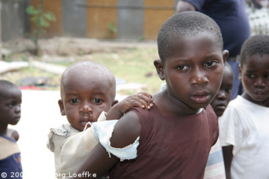 Flut Afrika: Bruder mit kleinem Bruder auf dem Arm