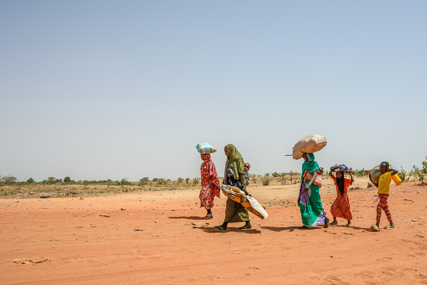 Frauen und Kinder flüchten mit ihrem Hab und Gut aus dem Sudan Frauen und Kinder flüchten mit ihrem Hab und Gut aus dem Sudan