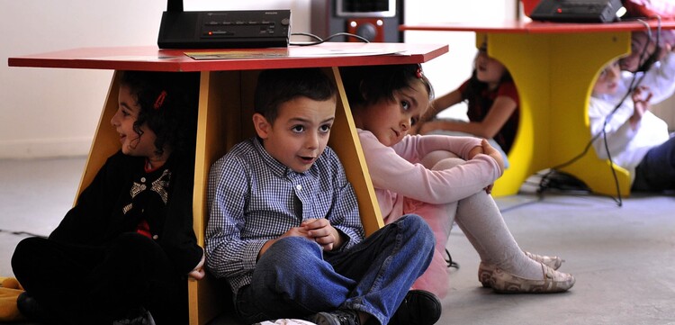 Kinder lernen spielerisch, wo sie bei einem Erdbeben Schutz finden. Kinder lernen spielerisch, wo sie bei einem Erdbeben Schutz finden.