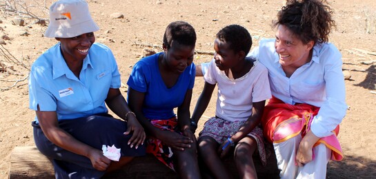 Kathryn Taetzsch sitzt bei Menschen in Afrika. Diese sind Betroffene der Auswirkungen des El Niño.