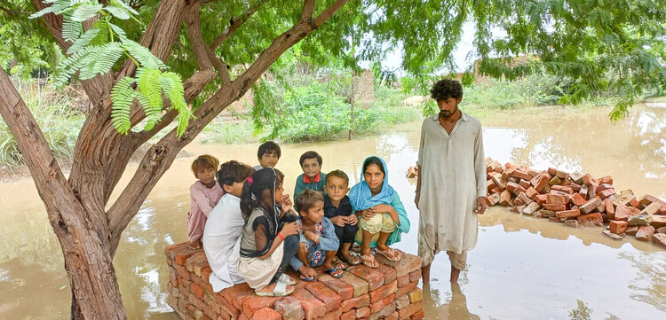 Kinder haben sich vor den Wassermassen auf die Überreste eines Hauses gerettet