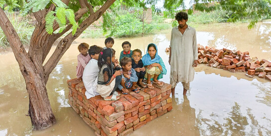 Kinder haben sich vor den Wassermassen auf die Überreste eines Hauses gerettet