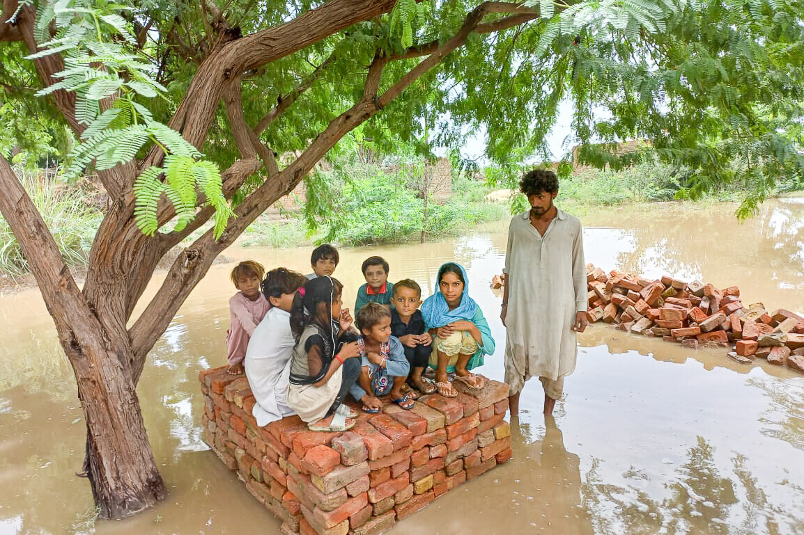 Kinder haben sich vor den Wassermassen auf die Überreste eines Hauses gerettet Kinder haben sich vor den Wassermassen auf die Überreste eines Hauses gerettet