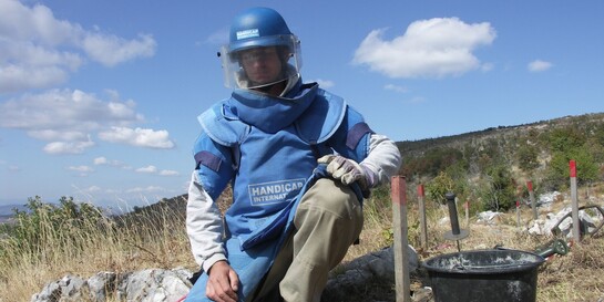 Ein Mann sucht in Schutzkleidung nach Minen