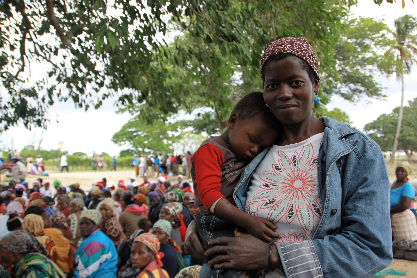 Eine Mama trägt ihr schlafendes Kind. In Mosambik verteilt CARE Nahrungsmittel und Wasser an die Betroffnen der Dürrekatastrophe.