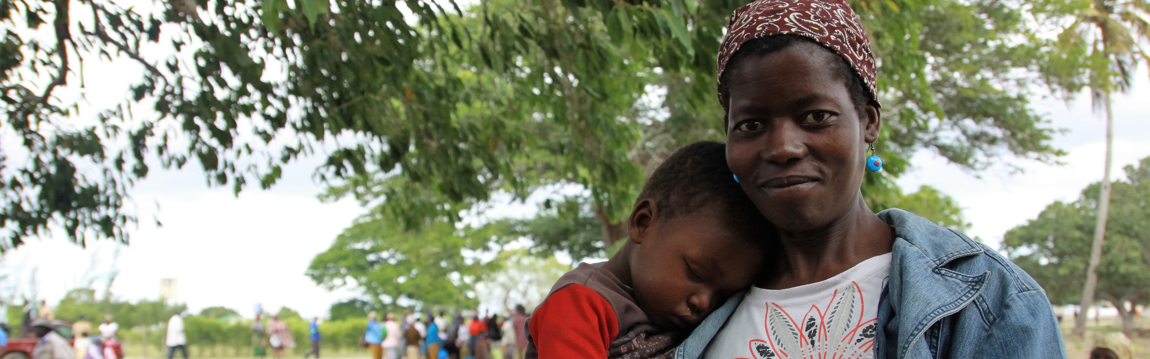 Eine Mama trägt ihren kleinen Jungen auf dem Arm. Während der schweren Dürre im süden Afrikas werden Lebensmittel und Wasser an betroffene Familien ausgeteilt.