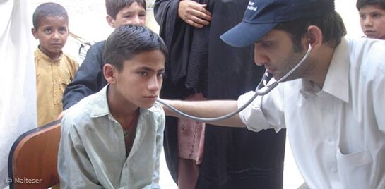 Flut Pakistan: Malteser Arzt untersucht Jungen