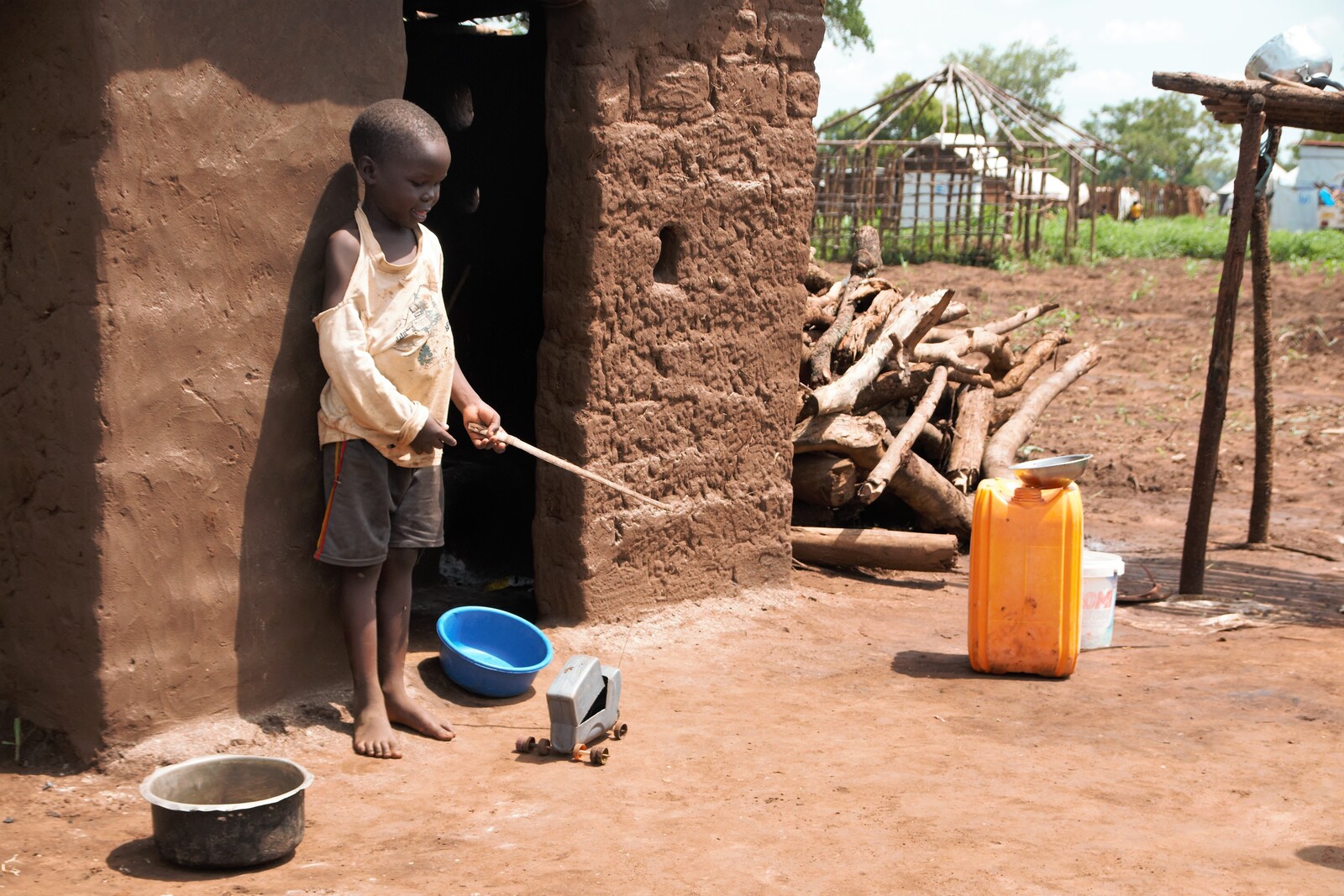 Der kleine Godi spielt im Flüchtlingscamp in Uganda mit seinem LKW