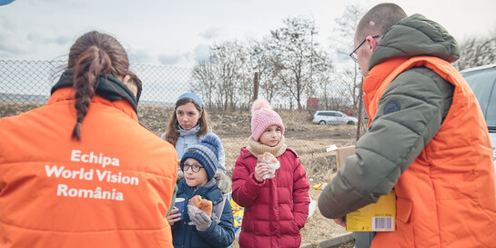 Helfende von World Vision Rumänien verteilen Essen an Kinder