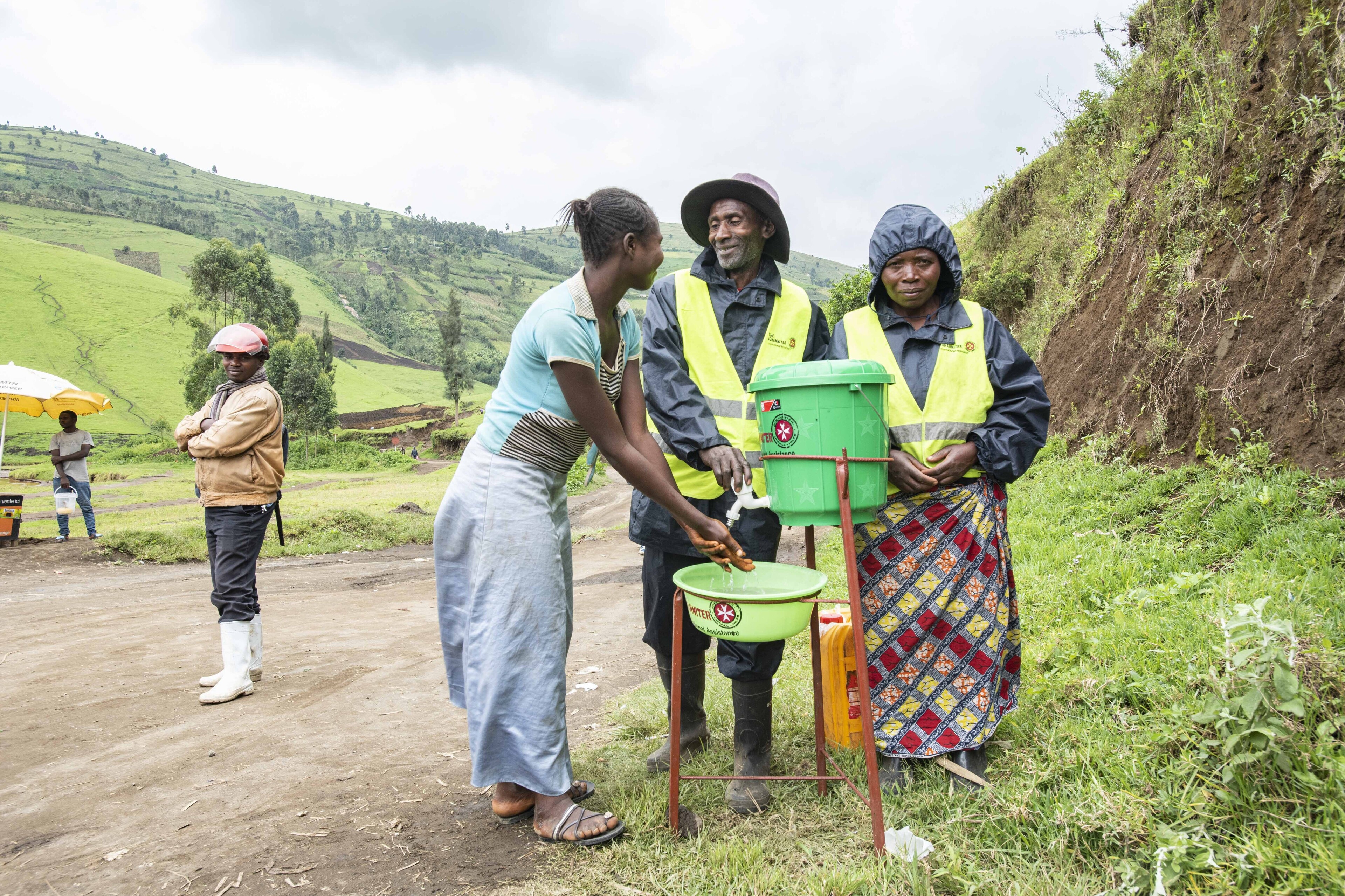 Zwei Frauen und Männer an einer Wasserstation in der DR Kongo Zwei Frauen und Männer an einer Trinkwasserstation in der DR Kongo