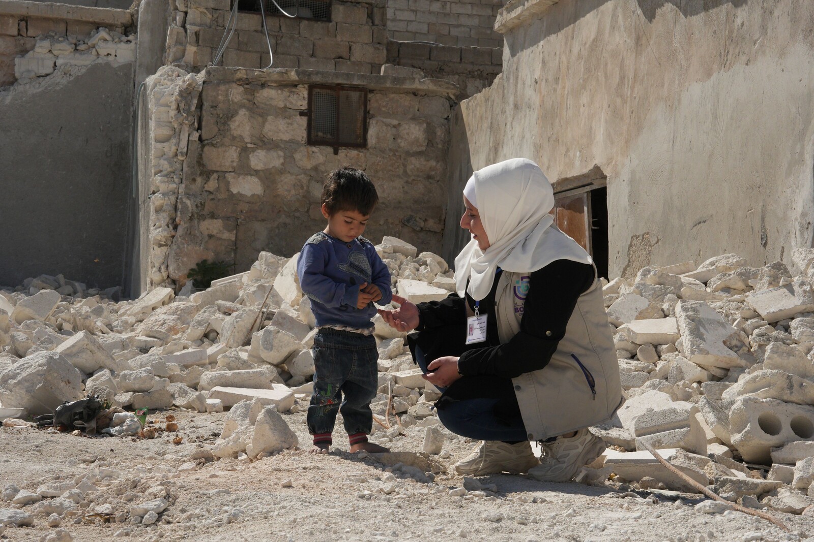Eine Helferin spricht mit einem Kind in Syrien