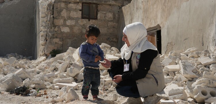 Eine Helferin spricht mit einem Kind in Syrien Eine Helferin spricht mit einem Kind in Syrien