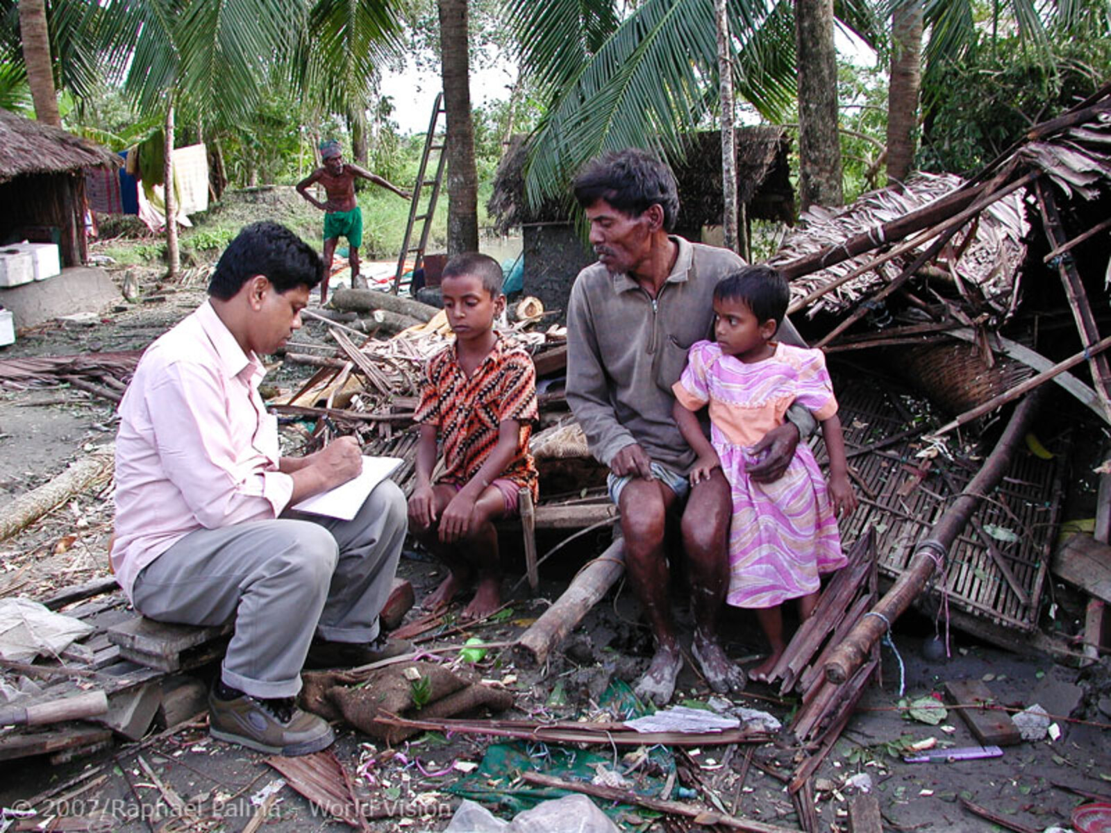 Nach dem Zyklon Sidr vom 15. November 2007 in Bangladesh sitzt eine Familie vor ihrem zerstörten Haus
