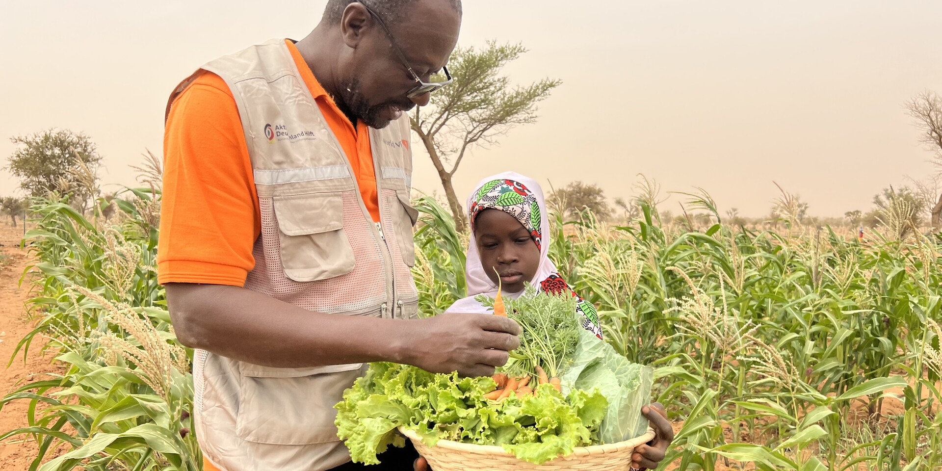 Helfer von World Vision mit Kind, Hilfsprojekt im Niger
