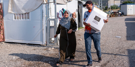 Ein Helfer der Organisation CARE verteilt an Betroffene des Erdbebens in Syrien Hygieneartikel