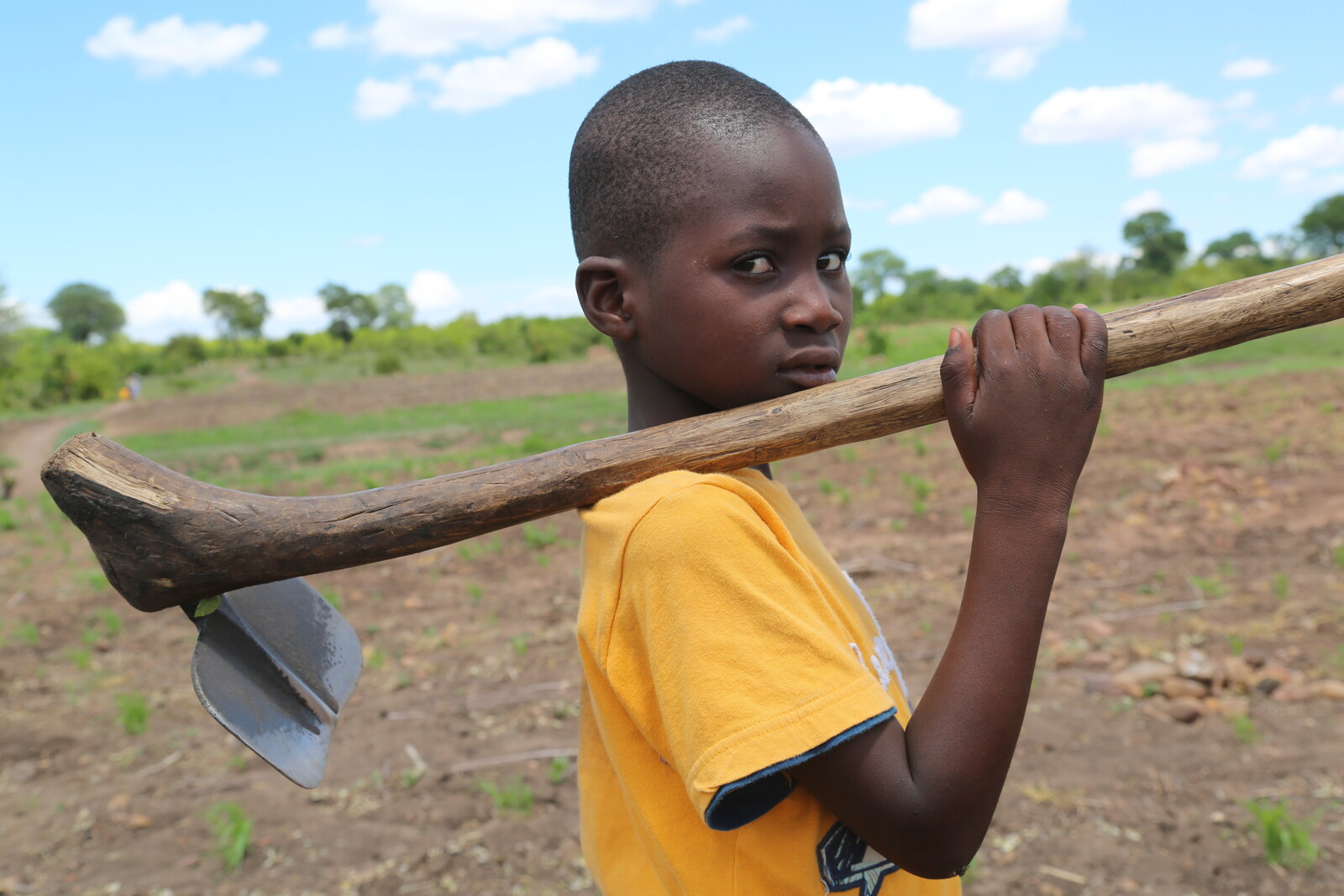 Der zehnjährige Martin hält eine Spitzhacke in der Hand. Er ist Opfer der Auswirkungen von El Niño.