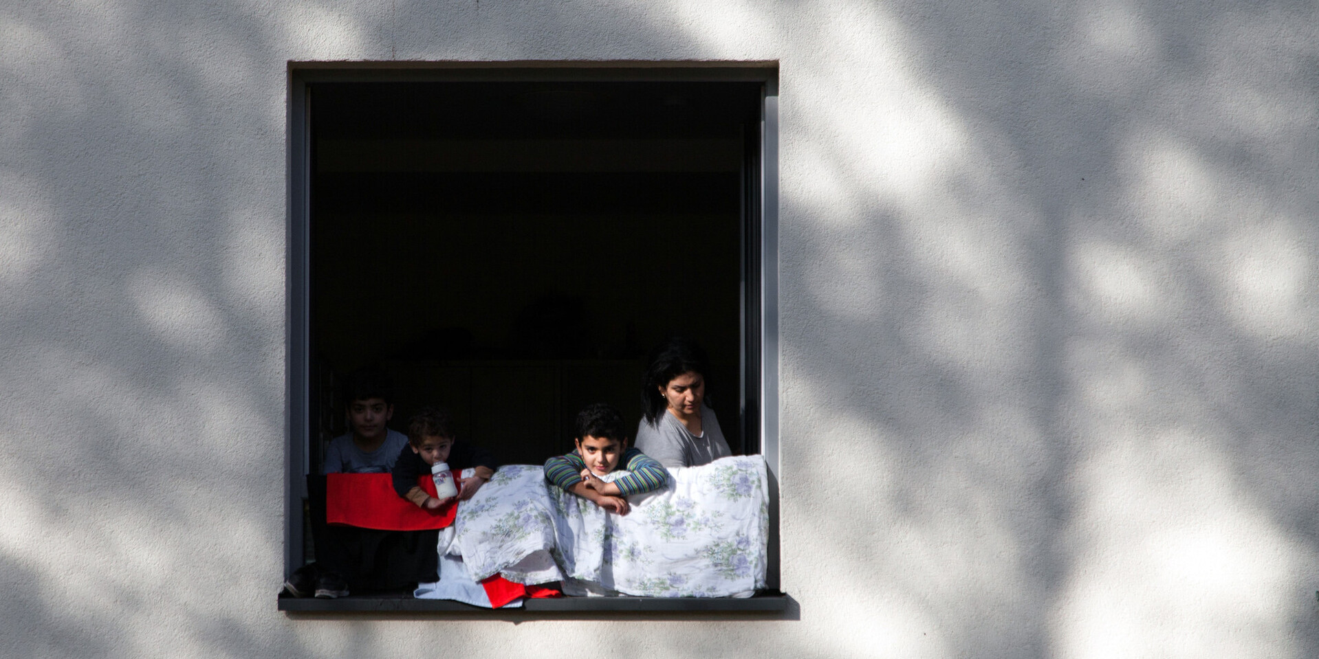 Alttext: Geflüchtete Familie am Fenster einer Flüchtlingsunterkunft in Deutschland (Archivbild) Alttext: Geflüchtete Familie am Fenster einer Flüchtlingsunterkunft in Deutschland (Archivbild)