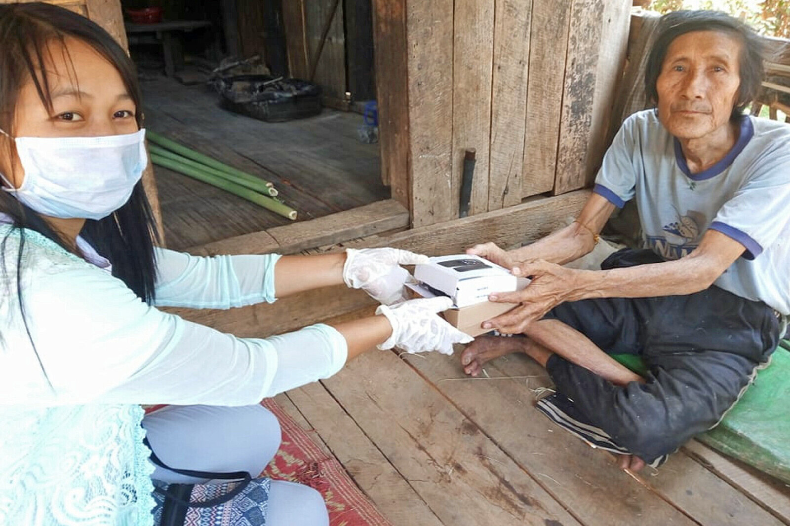 Eine Helferin verteilt Handys an Menschen in Myanmar
