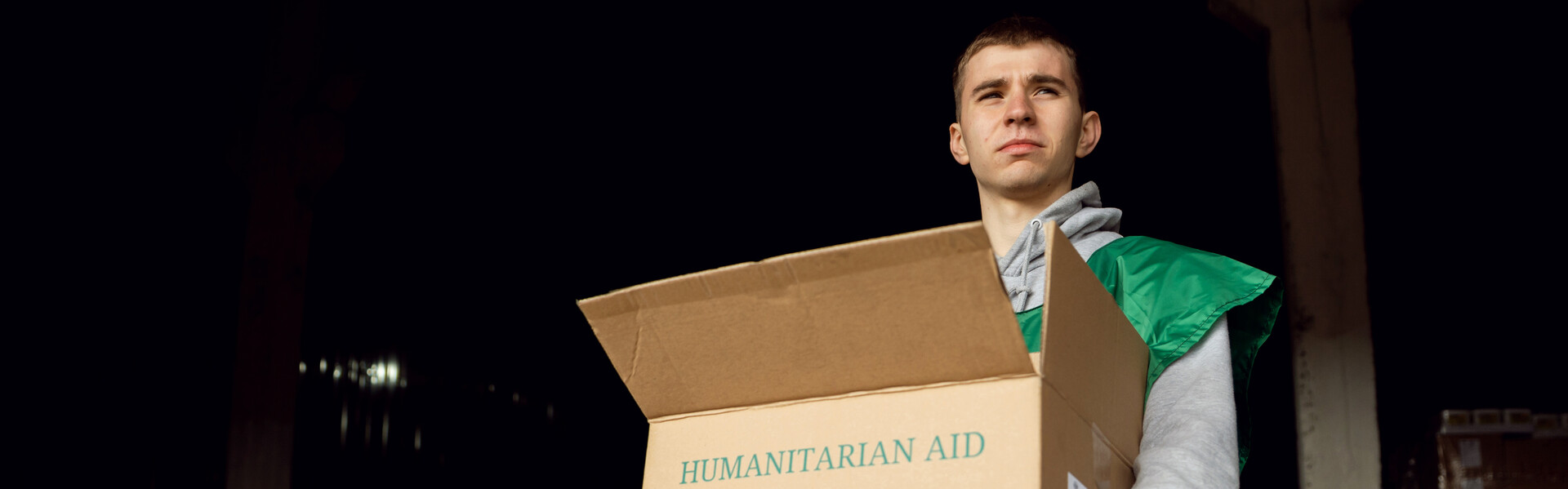 Ein Helfer der Organisation ADRA trägt ein Paket mit Hilfsgütern