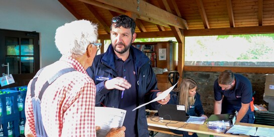 Wolfgang Heidinger (rechts) spricht mit einer Person, die vom Hochwasser in Deutschland betroffen war