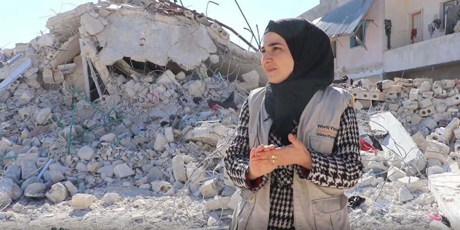 Eine Helferin in Syrien vor einem vom Erdbeben zerstörten Haus Eine Helferin in Syrien vor einem vom Erdbeben zerstörten Haus