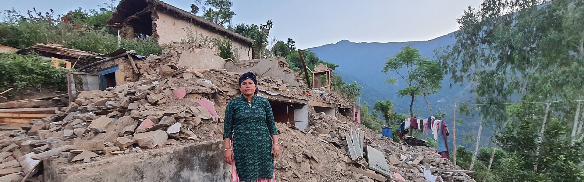 Eine Frau steht in Nepal nach dem Erdbeben auf Trümmern