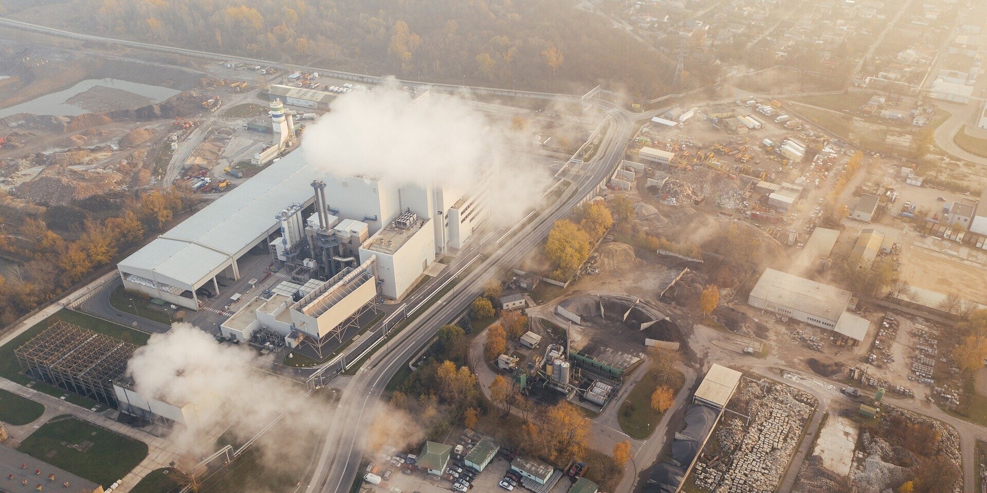 Eine Industrieanlage, die weiße Dampfschwaden in die Luft stößt Eine Industrieanlage, die weiße Dampfschwaden in die Luft stößt