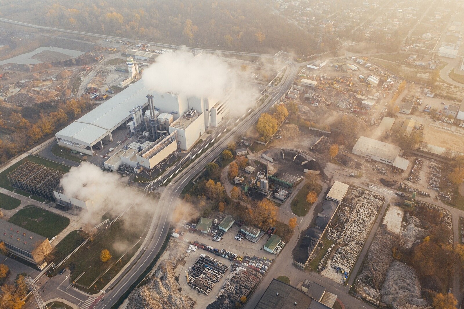 Eine Industrieanlage, die weiße Dampfschwaden in die Luft stößt 