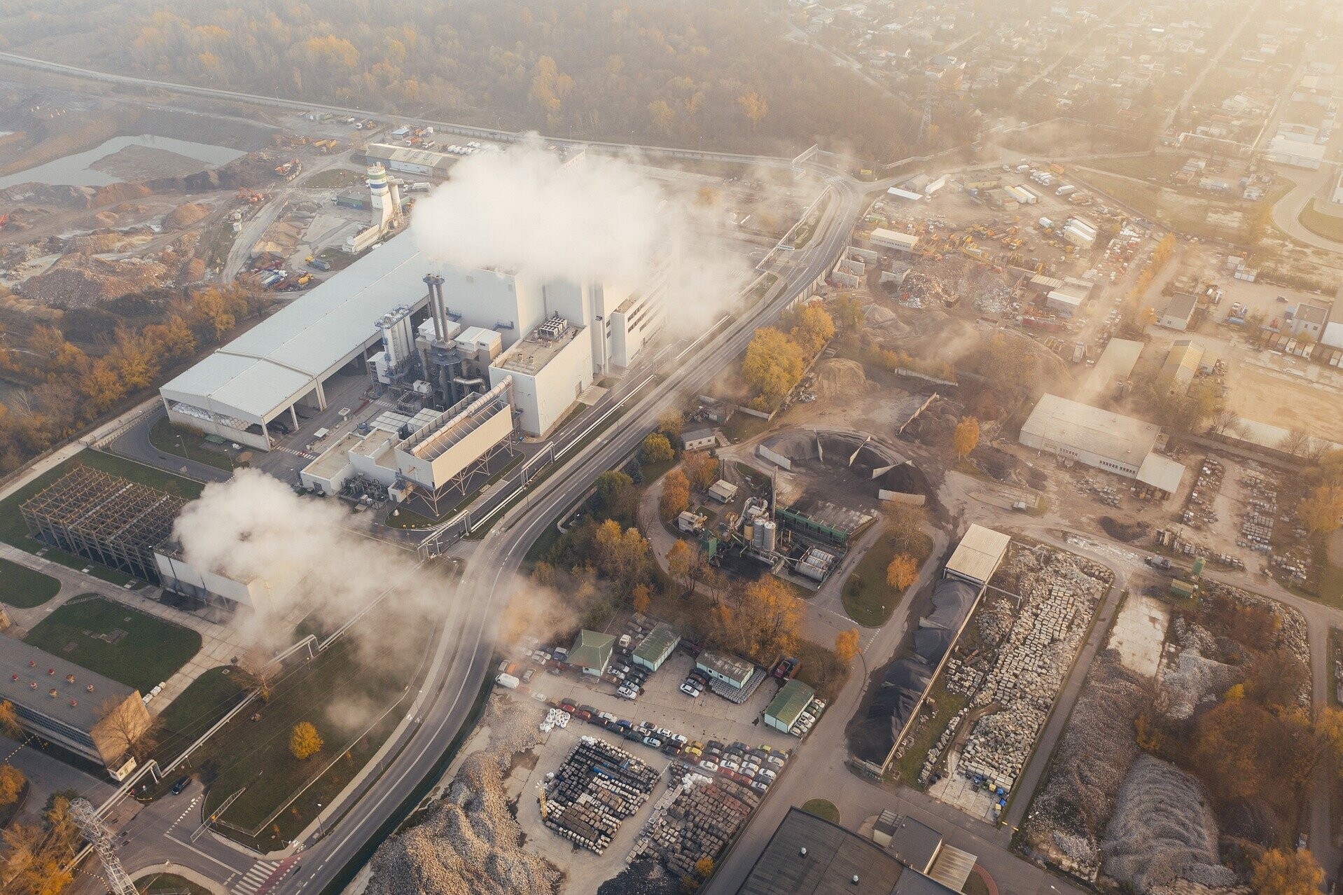 Eine Industrieanlage, die weiße Dampfschwaden in die Luft stößt Eine Industrieanlage, die weiße Dampfschwaden in die Luft stößt