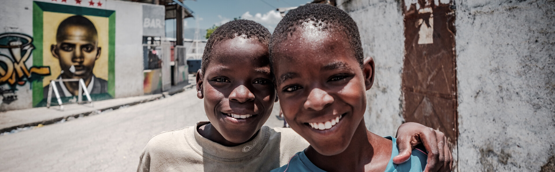 Zwei Freunde in Haiti umarmen sich.