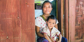 Eine Frau mit einem Kind auf dem Schoß in Thailand (Archivfoto)