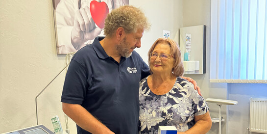 Ein Mitarbeiter von action medeor legt den Arm um eine Patientin