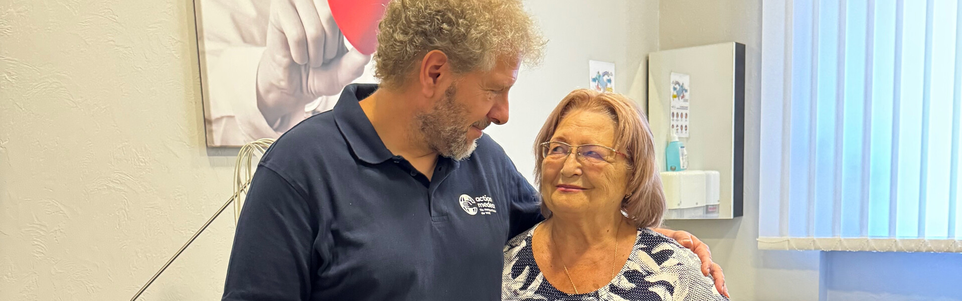 Ein Mitarbeiter von action medeor legt den Arm um eine Patientin