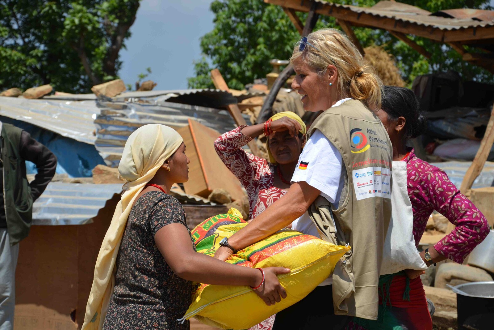 Nach dem schweren Erdbeben in Nepal werden erste Hilfsgüter verteilt. Eine Frau erhält Nahrungsmittel von einer Helferin.