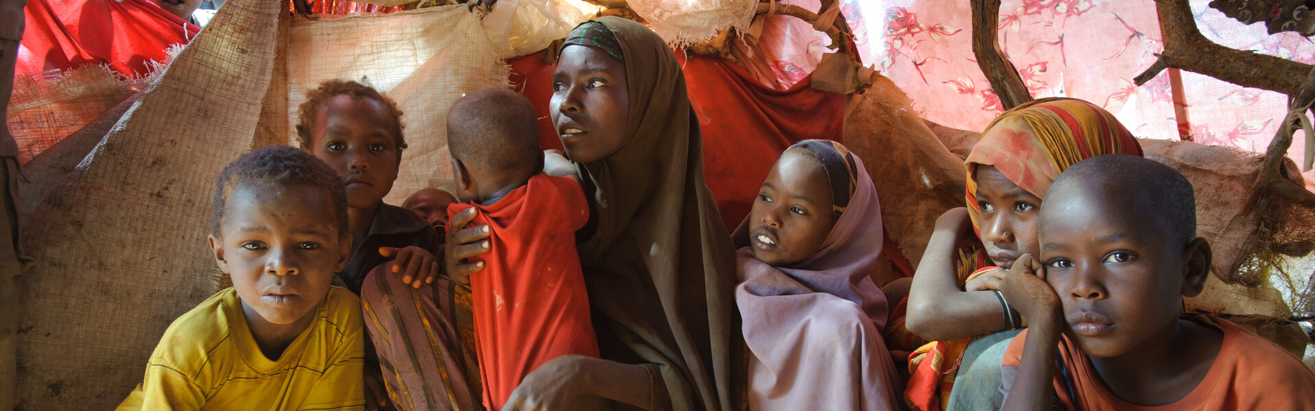 In Ostafrika ist die Situation der Menschen nach vielen Jahren Krieg ungewiss. Eine Familie sitzt in einem Flüchtlingszelt.