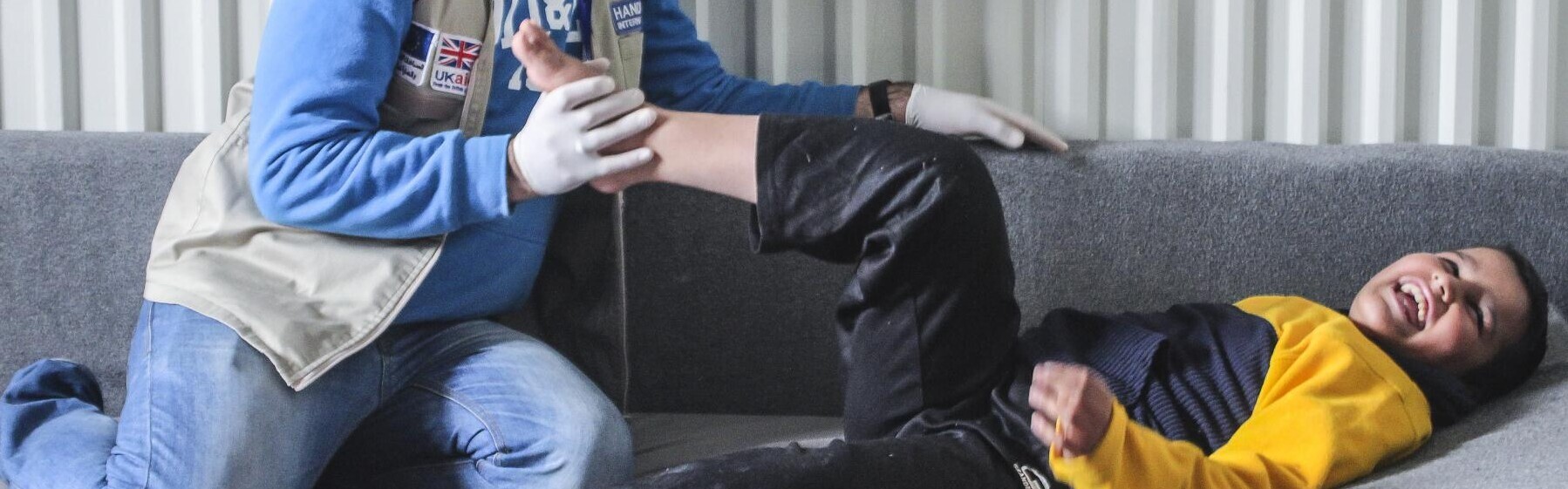 Ein Physiotherapeut macht Übungen mit einem verletzten Jungen. Handicap International hilft in Jordanien verletzten und traumatisierten Menschen.