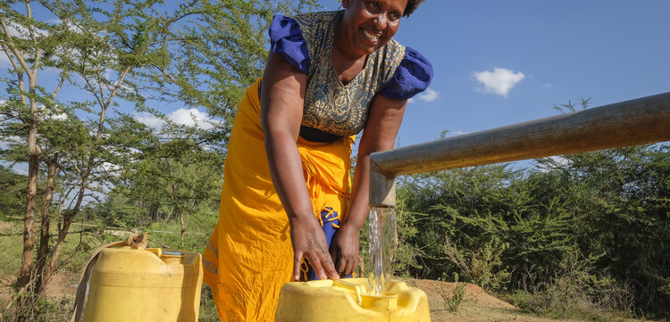 Hilfsprojekt in Kenia: Eine Frau holt Wasser an einem Brunnen Hilfsprojekt in Kenia: Eine Frau holt Wasser an einem Brunnen