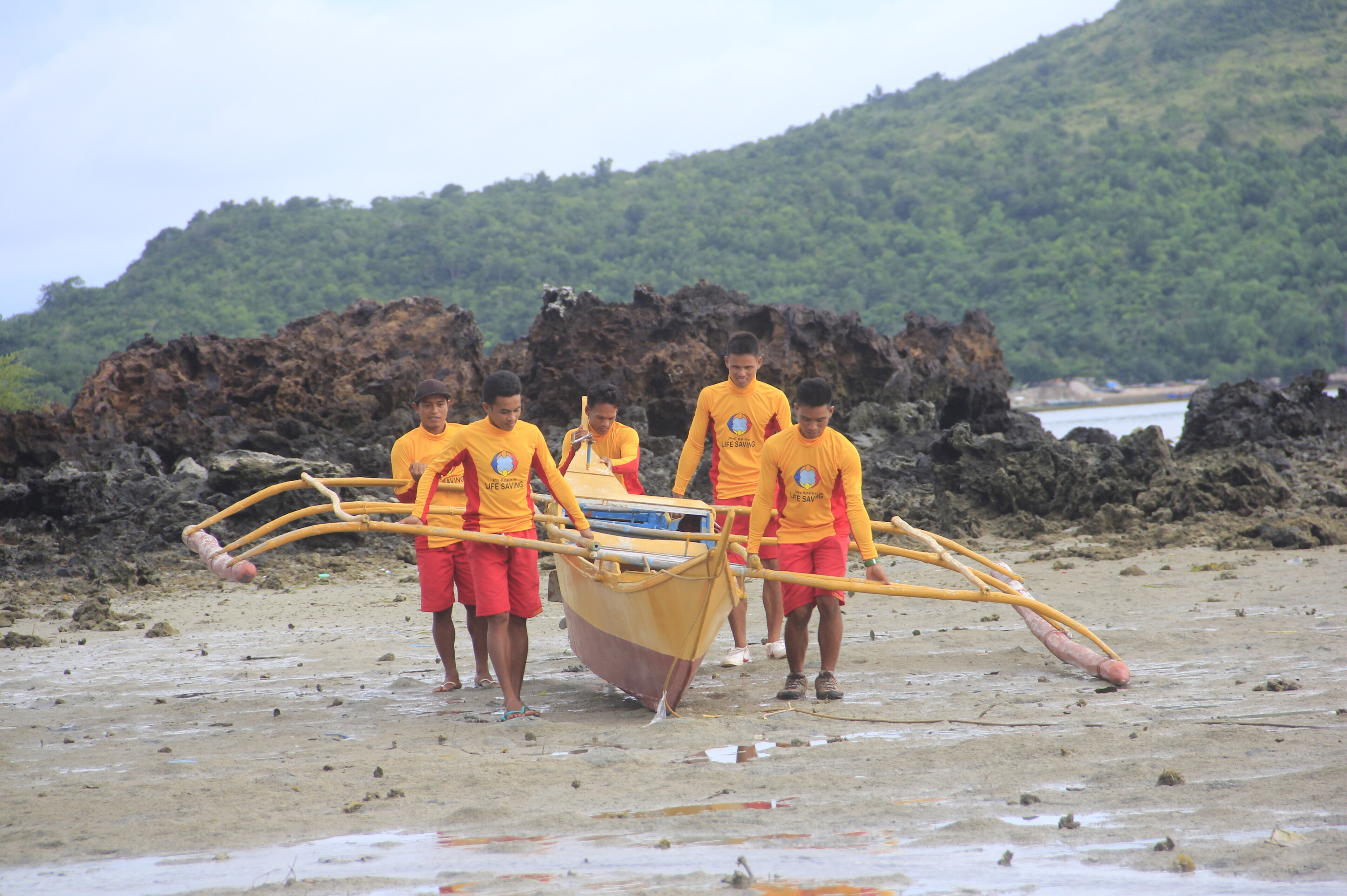 Rettungsschwimmer auf den Philippinen tragen ein Rettungsboot ins Wasser Rettungsschwimmer auf den Philippinen tragen ein Rettungsboot ins Wasser