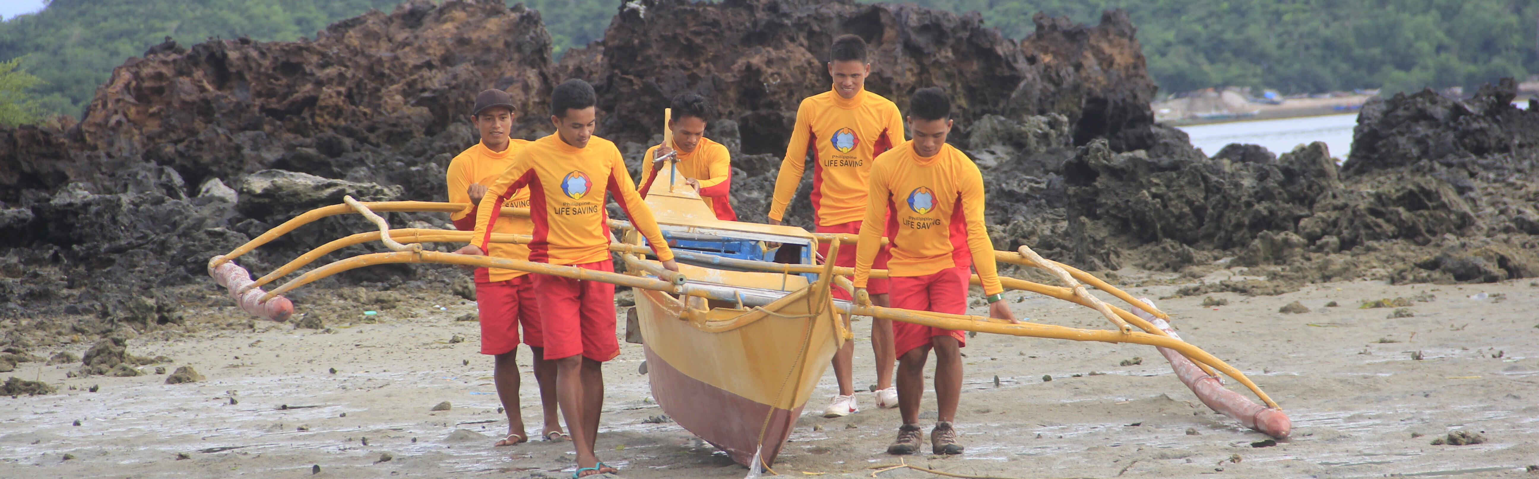Rettungsschwimmer auf den Philippinen tragen ein Rettungsboot ins Wasser