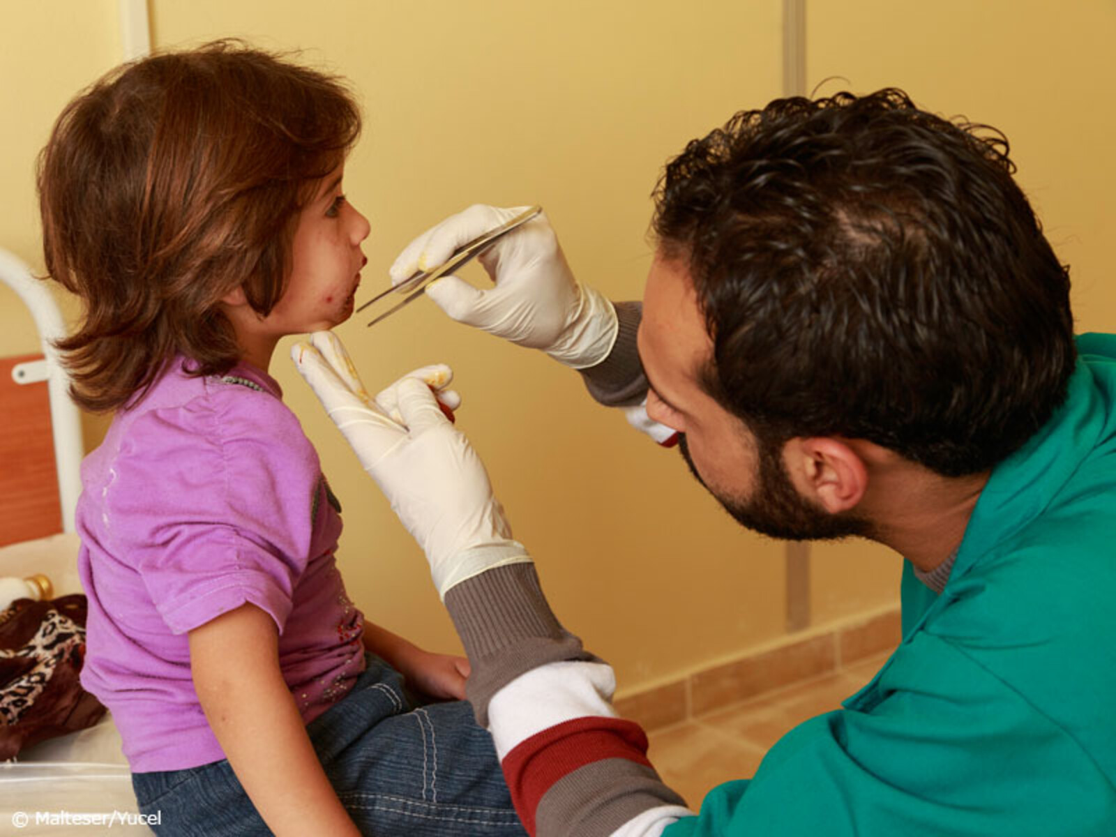 Ein Arzt behandelt ein syrisches Kind