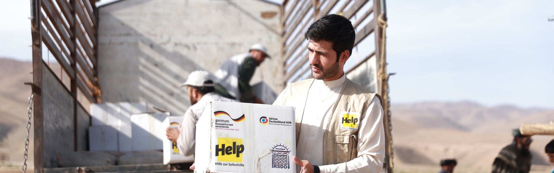 Ein Mann lädt Hilfsgüter aus einem Lastwagen Ein Mann lädt Hilfsgüter aus einem Lastwagen