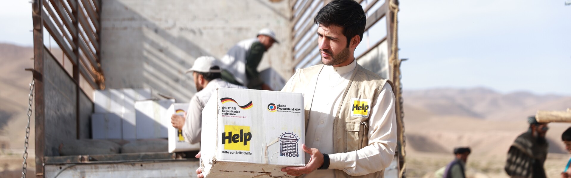 Ein Mann lädt Hilfsgüter aus einem Lastwagen