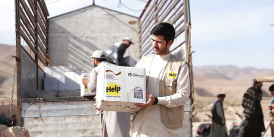 Ein Mann lädt Hilfsgüter aus einem Lastwagen