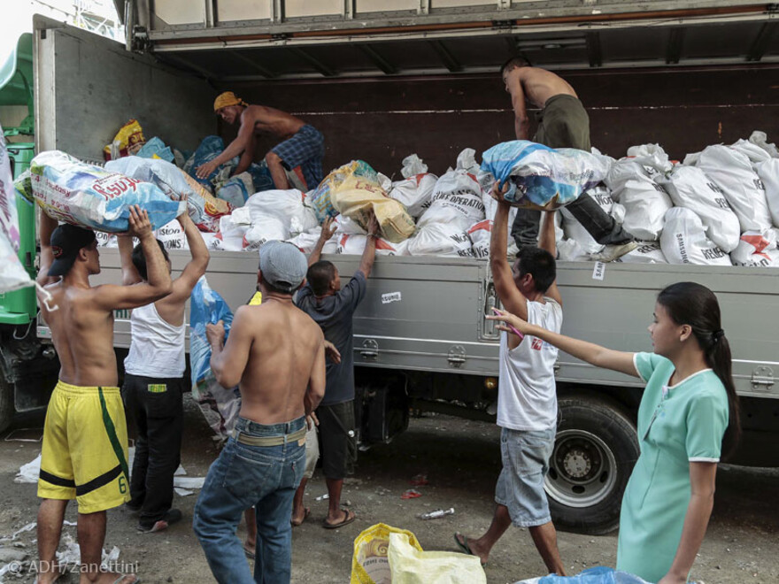 Die Säcke werden mit Hilfe von vielen Freiwilligen auf insgesamt 15 LKWs verladen