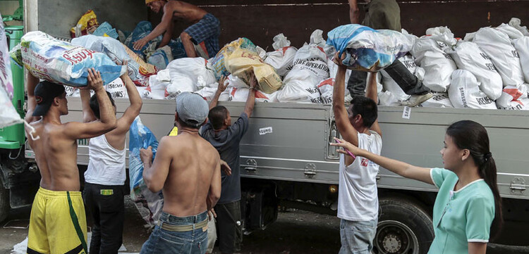 Die Säcke werden mit Hilfe von vielen Freiwilligen auf insgesamt 15 LKWs verladen