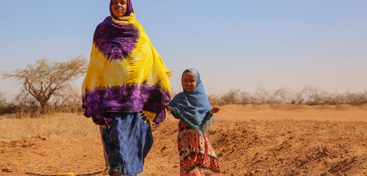 In Somalia geht eine Frau mit ihrem Kind durch die vertrocknete Landschaft. In Afrika herrscht eine extreme Dürre. In Somalia geht eine Frau mit ihrem Kind durch die vertrocknete Landschaft. In Afrika herrscht eine extreme Dürre.