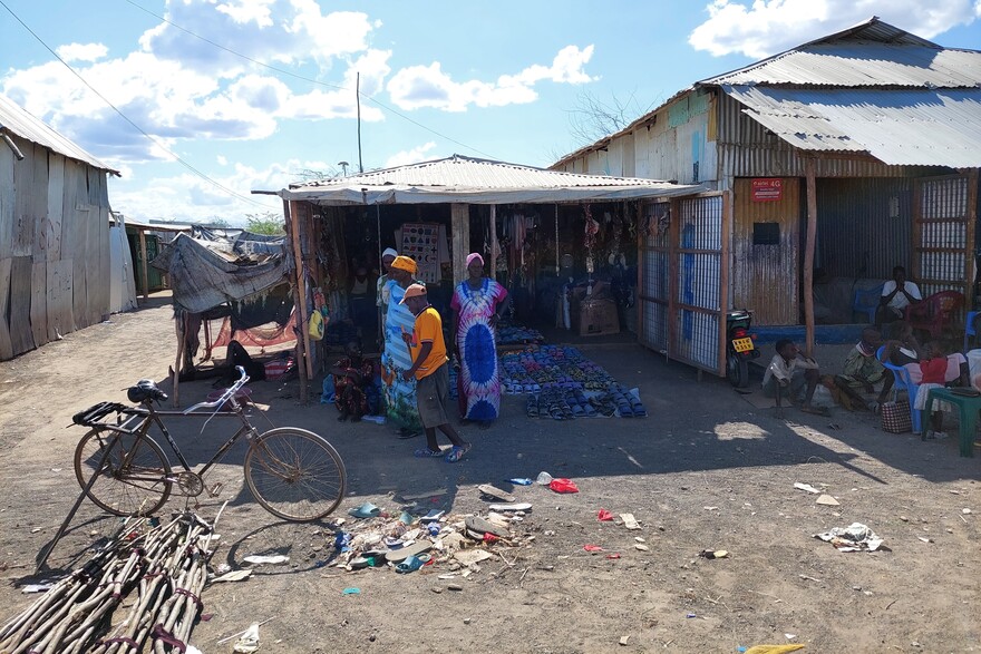 Menschen stehen vor einer Hütte im Geflüchtetencamp in Kakuma, Kenia Menschen stehen vor einer Hütte im Geflüchtetencamp in Kakuma, Kenia
