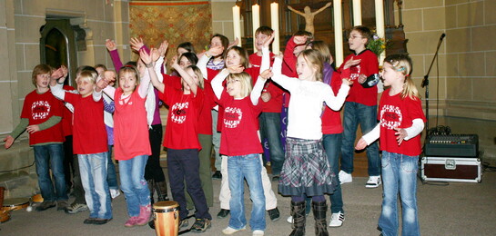 Eine Schulklasse startet in einer Kirche ein Benefizkonzert, um für Menschen in Not zu sammeln.