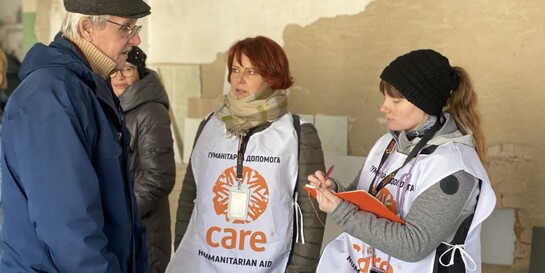 Zwei Helferinnen von CARE sprechen in der Ukraine mit einem Mann