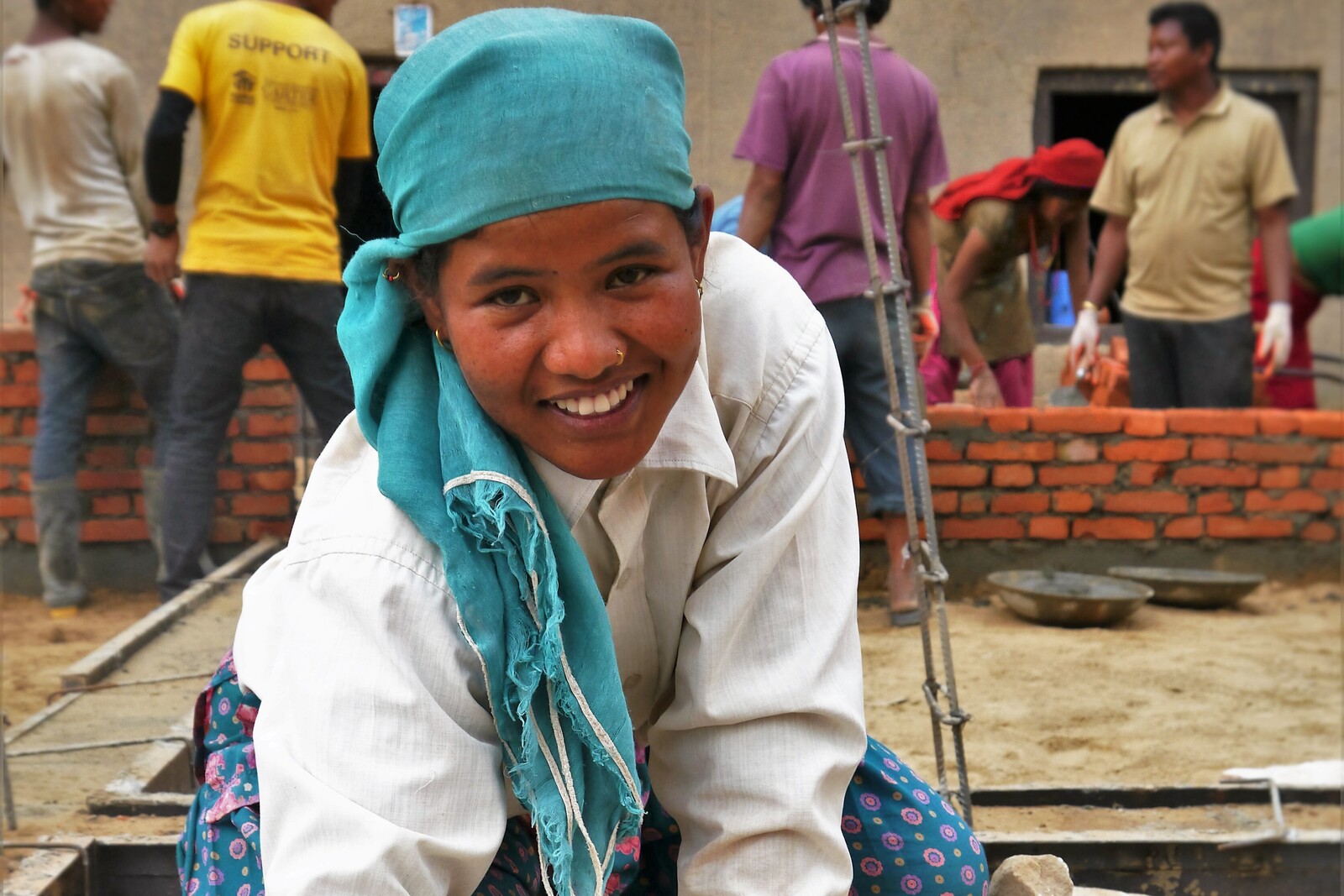 Eine Frau in Nepal hilft beim Bau erdbebensicherer Häuser